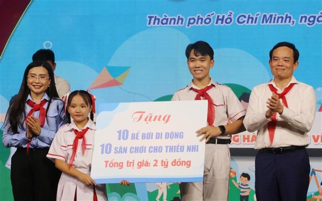 Phó Thủ tướng Chính phủ Trần Lưu Quang trao tặng bể bơi, sân chơi cho thiếu nhi tại chương trình. (Ảnh: Thu Hương/TTXVN) Tạo môi trường lành mạnh để trẻ em phát triển toàn diện ảnh 2