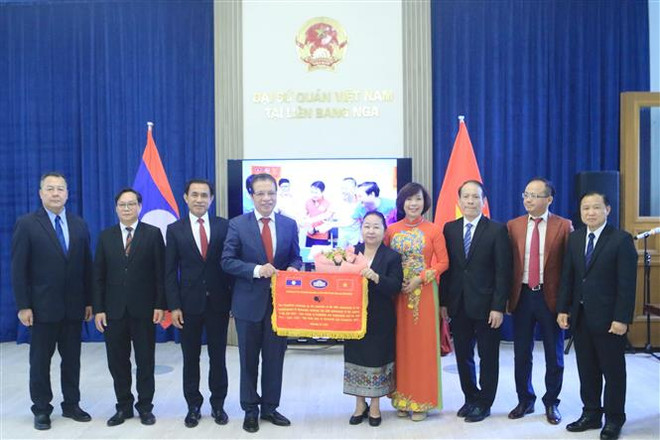 Các Đại sứ trao cờ lưu niệm giao lưu thể thao kỷ niệm 60 năm hai nước thiết lập quan hệ ngoại giao và 45 năm ký kết Hiệp ước Hữu nghị và Hợp tác Việt Nam-Lào. (Ảnh: Trần Hiếu/TTXVN) Sâu đậm tình đoàn kết và hữu nghị Việt Nam-Lào tại Liên bang Nga ảnh 3