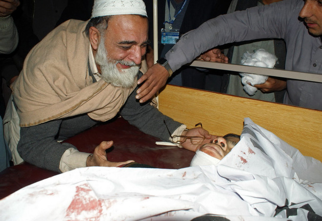Một người cha khóc thương con trai thiệt mạng trong vụ Taliban tấn công trường học ở Peshawar. (Nguồn: AFP/TTXVN) Pakistan: Phiến quân Taliban tấn công trường học đã bị tiêu diệt ảnh 1
