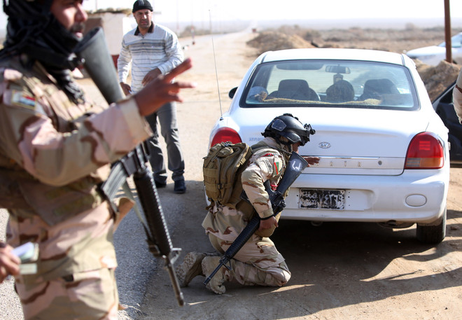 Binh sỹ Iraq kiểm tra các phương tiện giao thông của người Hồi giáo dòng Sunni đang sơ tán khỏi thành phố Fallujah. (Nguồn: AFP/TTXVN) Chính phủ Iraq nỗ lực tránh kịch bản tồi tệ nhất có thể xảy ra ảnh 1