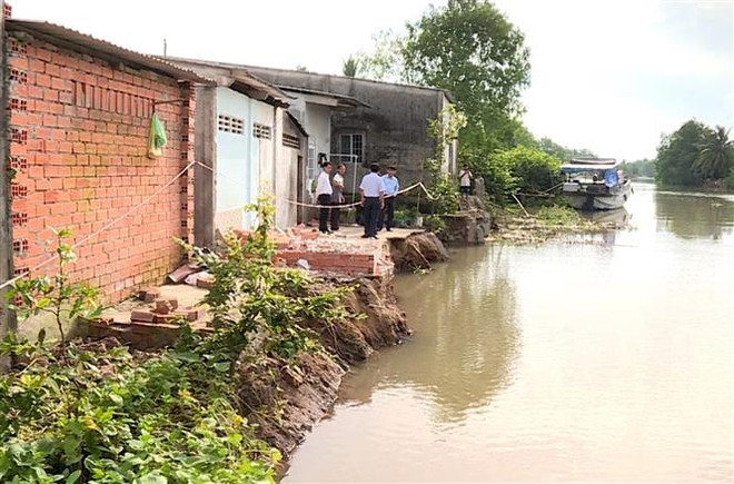Khu vực bờ sông bị sạt lở. (Ảnh: TTXVN phát) Vĩnh Long: Sạt lở kè kiên cố, ba căn nhà có nguy cơ rơi xuống sông ảnh 1