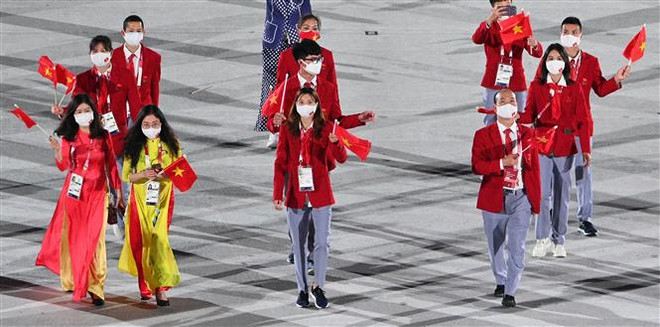 Đoàn thể thao Việt Nam diễu hành tại lễ khai mạc Olympic Tokyo 2020 trên sân vận động Olympic ở Tokyo (Nhật Bản), ngày 23/7/2021. (Ảnh: AFP/TTXVN) Thành tích của Đoàn thể thao Việt Nam trong ngày thi đấu đầu tiên ảnh 1