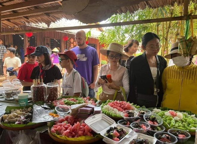 Du khách trong và ngoài nước thưởng thức các món bánh dân gian Nam Bộ tại khu du lịch Cồn Phụng, huyện Châu Thành (Bến Tre). (Ảnh: Chương Đài/TTXVN) Bến Tre phát triển du lịch thông minh gắn với bảo tồn giá trị di sản ảnh 3