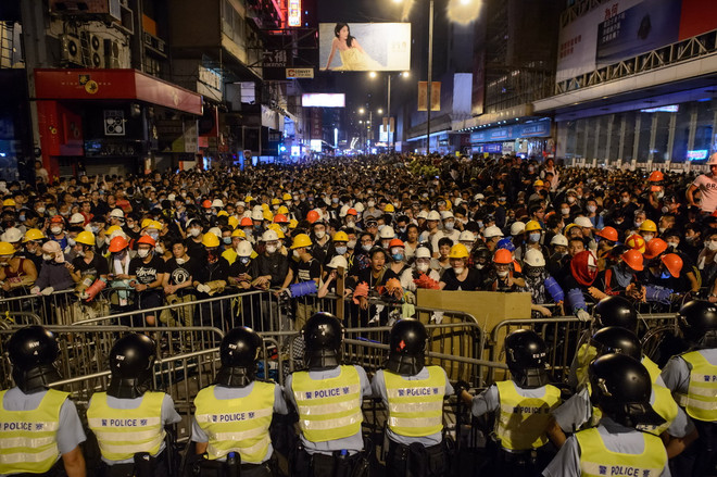 Cảnh sát được triển khai ngăn chặn người biểu tình chủ trương chiếm lại Mongkok ngày 19/10. (Nguồn: AFP/TTXVN) Cảnh sát Hong Kong bắt giữ hai đối tượng tấn công phóng viên ảnh 1