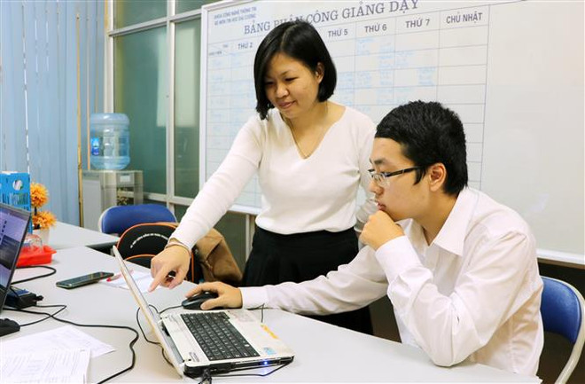 Cô Nguyễn Kim Anh, giảng viên Trường Đại học Hàng hải hướng dẫn sinh viên Nguyễn Đức Phát những kỹ năng quan trọng để bước vào cuộc thi toàn cầu. (Ảnh: Minh Thu/TTXVN) Sinh viên đại học Hàng hải VN giành huy chương Bạc tin học thế giới ảnh 2