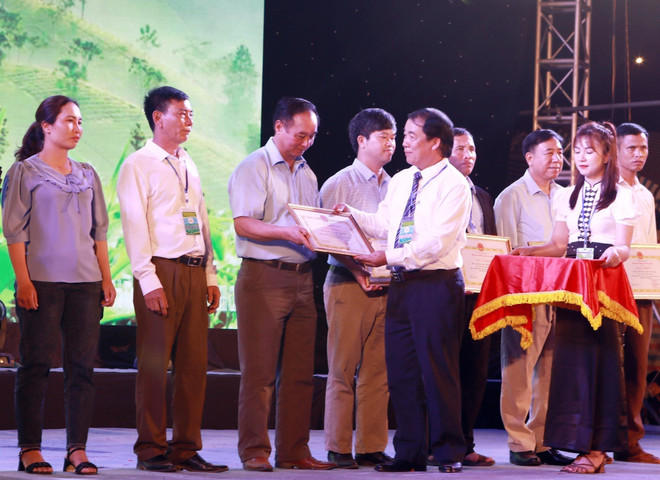Chủ tịch Ủy ban Nhân dân huyện Tân Uyên Nguyễn Thanh Văn trao Giấy khen cho các tập thể, hộ gia đình tiêu biểu trong chế biến, sản xuất chè trên địa bàn huyện. (Ảnh: Quý Trung/TTXVN) lai chau_le hoi tra 2.jpg