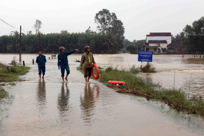 Lực lượng công an xã Hành Minh, huyện Nghĩa Hành túc trực kiểm tra các đường giao thông bị ngập lũ không cho người dân tự ý lưu thông. (Ảnh: Trần Lê Lâm/TTXVN) Quảng Ngãi căng mình lo an toàn cho dân các vùng bị ngập sâu ảnh 1