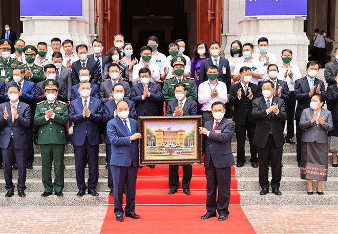 Chủ tịch nước Nguyễn Xuân Phúc tặng bức ảnh Phủ Chủ tịch cho Chủ tịch Quốc hội Lào Saysomphone Phomvihale, trong Lễ bàn giao, trao tặng Nhà Quốc hội mới - quà tặng của Đảng, Nhà nước và nhân dân Việt Nam cho Đảng, Nhà nước và nhân dân Lào, ngày 10/8/2021. (Ảnh: Thống Nhất/TTXVN) 10 sự kiện tiêu biểu của Quốc hội Việt Nam trong năm 2021 ảnh 9