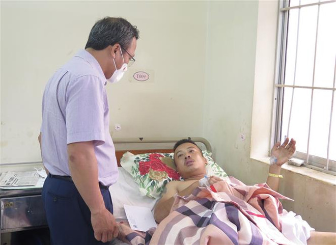Ông Khuất Việt Hùng - Phó Chủ tịch chuyên trách Ủy ban An toàn giao thông Quốc gia thăm hỏi nạn nhân Nguyễn Văn Đức (32 tuổi, trú Hải Hậu, Nam Định) bị thương nặng đang nằm điều trị tại Bệnh viện Đa khoa tỉnh Khánh Hòa. (Ảnh: Phan Sáu/TTXVN) Thăm hỏi nạn nhân trong vụ tai nạn giao thông tại Khánh Hòa ảnh 1