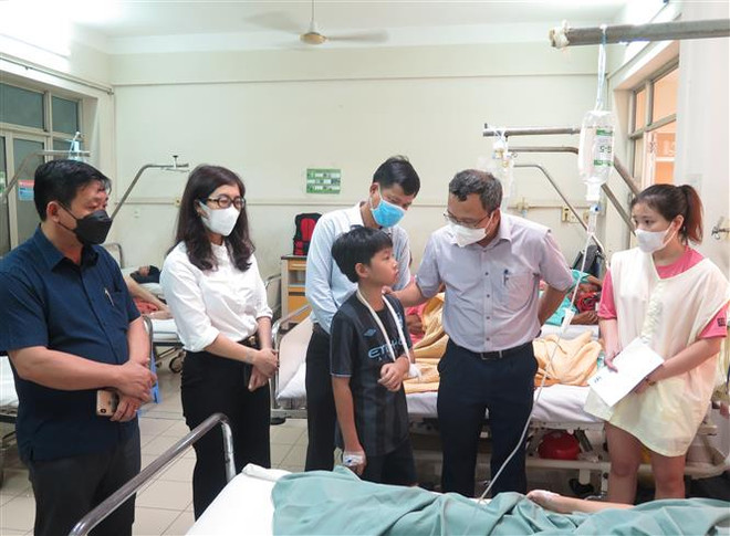 Ông Khuất Việt Hùng - Phó Chủ tịch chuyên trách Ủy ban An toàn giao thông Quốc gia (thứ hai, phải) thăm hỏi nạn nhân bị thương nặng đang nằm điều trị tại Bệnh viện Đa khoa tỉnh Khánh Hòa. (Ảnh: Phan Sáu/TTXVN) Thăm hỏi nạn nhân trong vụ tai nạn giao thông tại Khánh Hòa ảnh 4