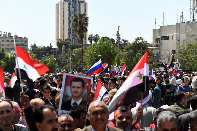 Người dân Syria đã đổ xuống đường phố Aleppo, bày tỏ sự ủng hộ Tổng thống Bashar al-Assad và quân đội Chính phủ, ngày 14/4. (Nguồn: AFP/TTXVN) Người dân Syria xuống đường ủng hộ tổng thống Bashar al-Assad ảnh 1