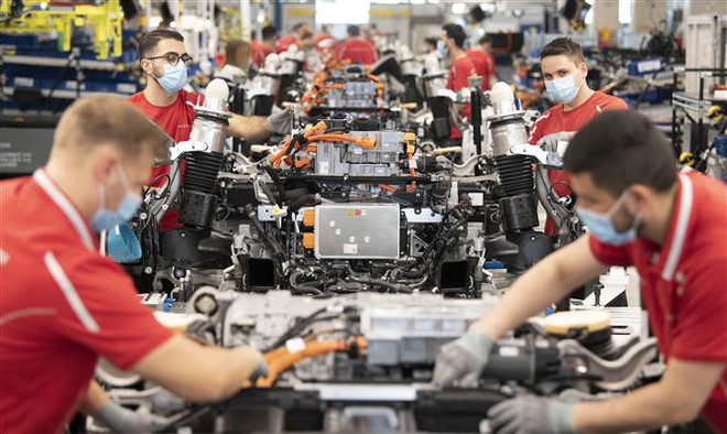 Công nhân làm việc trên dây chuyền lắp ráp xe ôtô của hãng Porsche ở Stuttgart, miền Nam Đức, ngày 12/5/2020. (Ảnh: AFP/TTXVN) Suy thoái kinh tế tại Đức có thể ít trầm trọng hơn dự báo ảnh 1