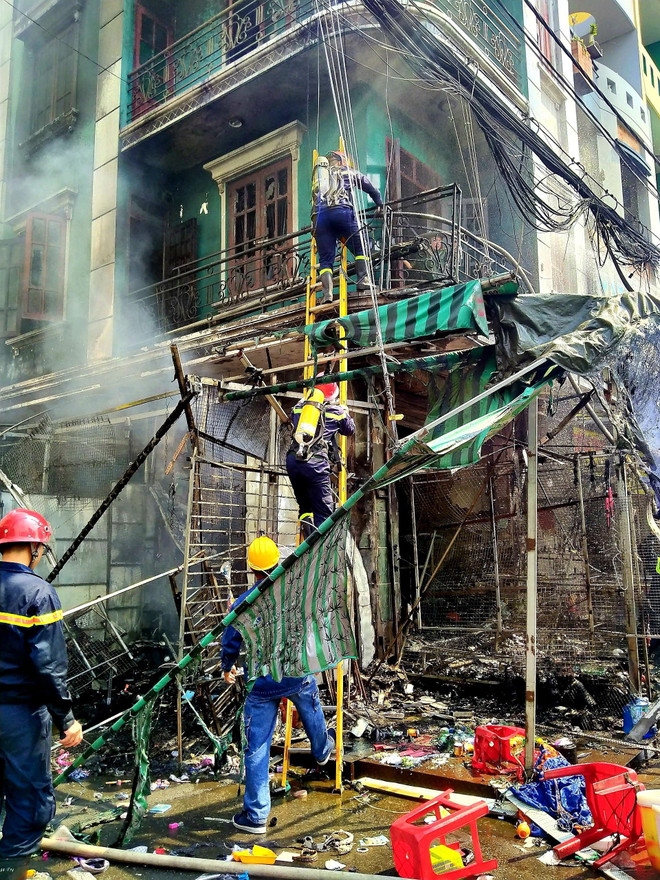 Lực lượng chức năng giải cứu người mắc kẹt trong vụ cháy. (Nguồn: TTXVN phát) Thành phố Hồ Chí Minh: Giải cứu kịp thời người mắc kẹt trong đám cháy ảnh 1