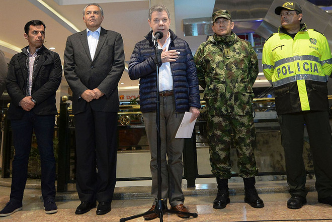 Tổng thống Colombia Juan Manuel Santos (giữa) thông báo số người thiệt mạng trong vụ đánh bom xảy ra sáng 18/6 (theo giờ Hà Nội) tại trung tâm thương mại Centro Andino ở thủ đô Bogota đã tăng lên 3 người. (Nguồn: AFP/TTXVN) Tổng thống Colombia họp hội đồng an ninh quốc gia sau vụ đánh bom ảnh 1