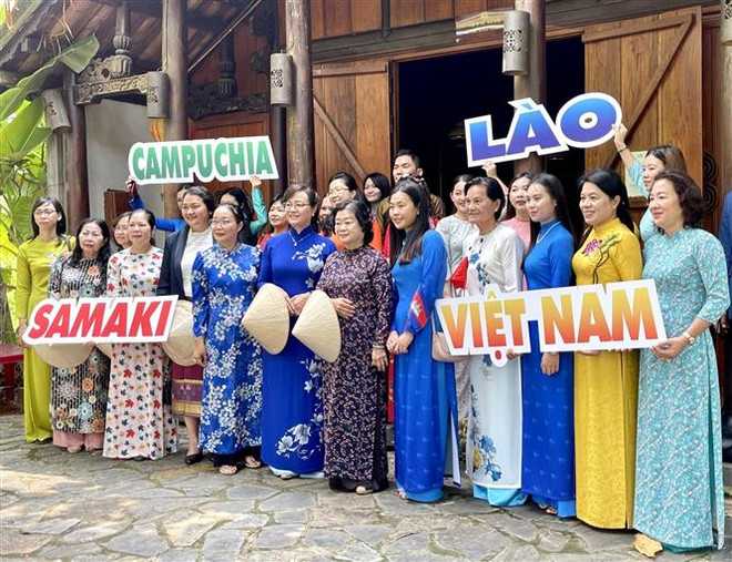 Bà Trương Mỹ Hoa, nguyên Bí thư Trung ương Đảng, nguyên Phó Chủ tịch nước chụp ảnh lưu niệm cùng các sinh viên Lào, Campuchia. (Ảnh: Thu Hương/TTXVN) Trao tặng áo dài cho sinh viên Lào, Campuchia đang học tập tại TP.HCM ảnh 1