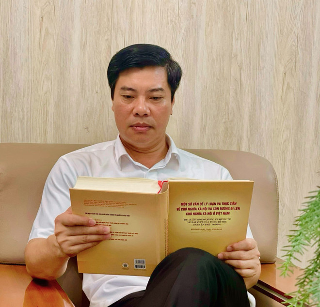 Ông Nguyễn Minh Thắng, Ủy viên Ban Thường vụ, Trưởng ban Tuyên giáo Thành ủy Chí Linh đang xem sách của Tổng Bí thư Nguyễn Phú Trọng. (Ảnh: Mạnh Tú/TTXVN) Nguyen Minh Thang.jpg