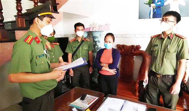 Cơ quan An ninh điều tra Công an tỉnh Bình Định đọc quyết định khởi tố và khám xét nhà ở của một bị can liên quan đến vụ án. (Ảnh: TTXVN) Bình Định: Khởi tố 16 bị can làm giả con dấu của cơ quan, tổ chức ảnh 1