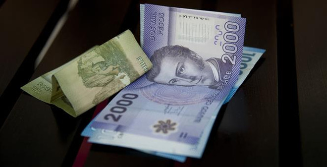 Đồng tiền peso Chile tại Santiago. (Ảnh: AFP/TTXVN) Mỹ Latinh trước áp lực tăng lãi suất do đồng nội tệ mất giá ảnh 1