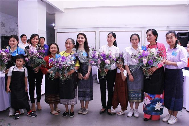 Du học sinh Lào, Campuchia cùng các gia đình người Việt tham gia cắm hoa nghệ thuật tại chương trình "Ngày hội Gia đình Việt Nam-Lào-Campuchia" tại Thành phố Hồ Chí Minh, ngày 26/6/2022. (Ảnh: Thu Hương/TTXVN) Trường năng khiếu Vientiane - một biểu tượng của quan hệ Lào-Việt Nam ảnh 2