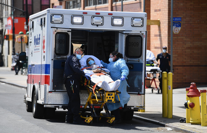 Nhân viên y tế chuyển nạn nhân nhiễm COVID-19 tới bệnh viện ở Brooklyn, New York, Mỹ, ngày 7/4/2020. (Nguồn: AFP/TTXVN) Dịch COVID-19 đến 6h sáng 9/4: Số ca mắc vượt ngưỡng 1,5 triệu ảnh 1