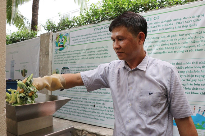 Rác hữu cơ được đưa vào máy xử lý rác để tách phần bã và phần nước sau đó trộn đều với chế phẩm vi sinh làm thành phân bón hữu cơ. (Ảnh: Lê Xuân/TTXVN) xu ly rac huu co 1.jpg