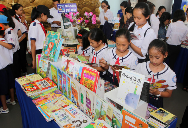 Học sinh huyện Quảng Điền (Thừa Thiên-Huế) tham quan triển lãm và đọc sách trong Ngày sách Việt Nam. (Ảnh: Hồ Cầu/TTXVN) Nỗ lực hành động để tăng tình yêu với sách trong cộng đồng ảnh 1