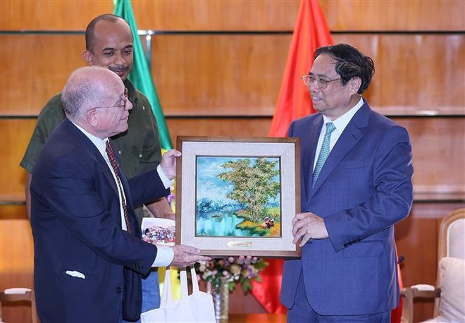 Thủ tướng Phạm Minh Chính tặng bức tranh cây tre Việt Nam cho ông Pedro de Oliveira, Tổng Thư ký Hội Hữu nghị Brazil-Việt Nam. (Ảnh: Dương Giang/TTXVN) Thủ tướng Phạm Minh Chính tiếp Lãnh đạo Hội Hữu nghị Brazil-Việt Nam ảnh 1