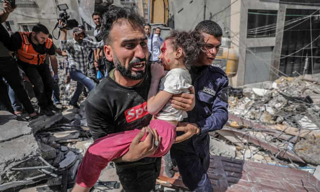 Một ông bố Palestine bế con gái khỏi đống đổ nát ở Gaza sau đợt không kích của Israel (Nguồn: EPA) Xung đột Israel-Palestine: VN lên án tấn công nhằm vào dân thường ảnh 1
