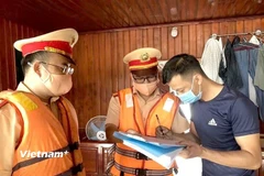 Lực lượng Cảnh sát giao thông đường thủy hướng dẫn các chủ phương tiện ký cam kết chấp hành nghiêm Luật Giao thông đường thủy. (Ảnh: Nguyễn Thảo/Vietnam+)