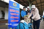 Cán bộ công đoàn tại Đồng Nai hỗ trợ người lao động vận chuyển hành lý và chuẩn bị lên tàu về quê đón Tết. (Ảnh: Lê Xuân/TTXVN)