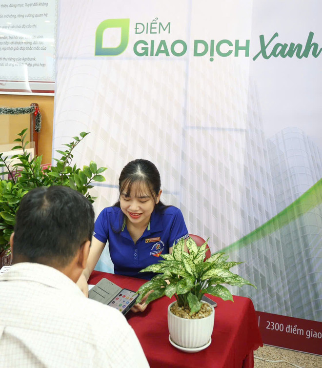 Cán bộ Agribank đang hướng dẫn khách hàng trải nghiệm các dịch vụ số của Agribank. (Ảnh: Vietnam+) 87f9db7eae481e164759.jpg