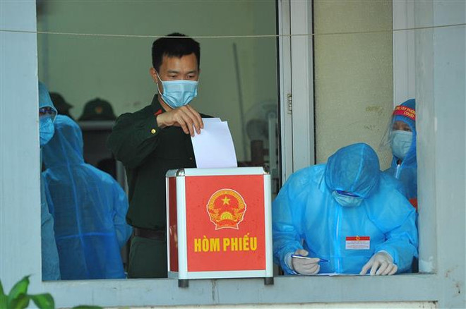 Các cử tri làm nhiệm vụ tại Khu cách ly tập trung, bỏ phiếu bầu tại đơn vị bầu cử số 7, phường Trang Hạ, thị xã Từ Sơn. (Ảnh: Minh Đức/TTXVN) Bầu cử QH và HĐND: 16 tỉnh, thành phố hoàn thành việc bầu cử sớm ảnh 1