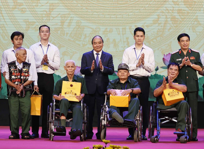 Chủ tịch nước Nguyễn Xuân Phúc và Đại tướng, Bộ trưởng Quốc phòng Phan Văn Giang trao quà cho người có công và các thương bệnh binh. (Ảnh: Thống Nhất/TTXVN) Lễ kỷ niệm Ngày Thương binh-liệt sỹ và Tuyên dương Người có công ảnh 3