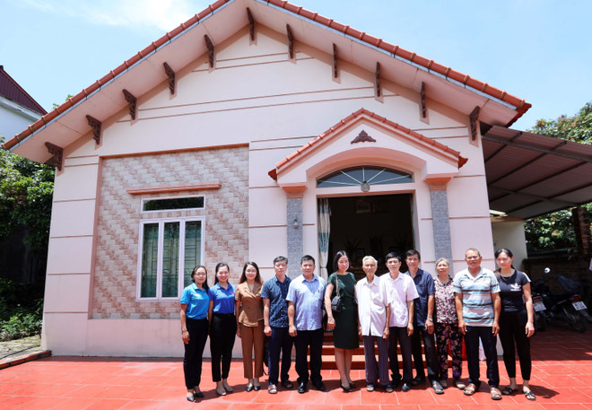 Tổng Giám đốc Vũ Việt Trang và cán bộ, phóng viên TTXVN chụp ảnh chung với thân nhân liệt sỹ, nhà báo Hoàng Văn Đáo. (Ảnh: Hoàng Hiếu/TTXVN) Ngày Thương binh-Liệt sỹ: Hành trình gần 40 năm khắc khoải tìm cha ảnh 3