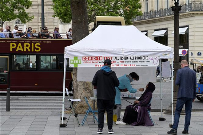 Nhân viên y tế lấy mẫu xét nghiệm COVID-19 cho người dân tại Paris, Pháp ngày 1/7/2022. (Ảnh: AFP/TTXVN) Cơ quan y tế Pháp giải thích hiện tượng tái nhiễm virus SARS-CoV-2 ảnh 1