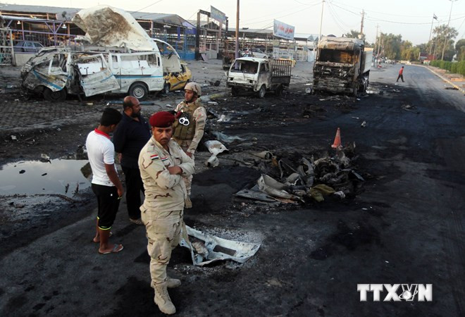 Binh sỹ Iraq điều tra tại hiện trường vụ đánh bom tại trạm kiểm soát ở quận Sadr City, Baghdad, ngày 14/10. (Ảnh: AFP/TTXVN) Đánh bom ở trung tâm Baghdad, hơn 40 người thương vong ảnh 1
