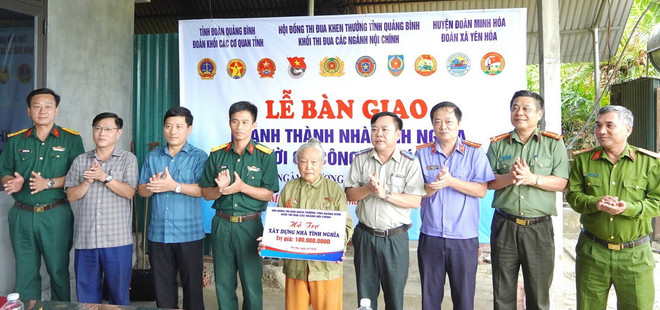 Khối thi đua các ngành Nội chính trao biển hỗ trợ kinh phí xây nhà cho gia đình bà Lê Thị Nhung tại chương trình. (Ảnh: TTXVN phát) Quang binh khanh_thanh_trao_tang_nha_tinh_nghia_cho_gia_dinh_co_cong_voi_cach_mang.jpg