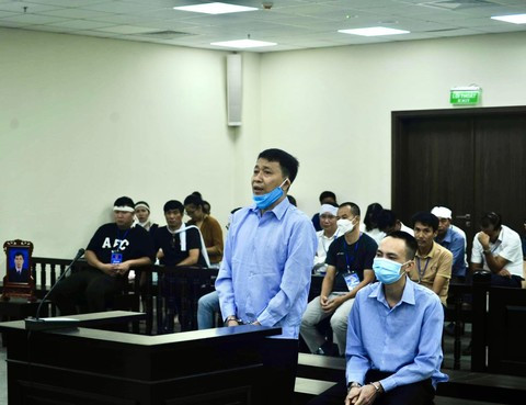 Bị cáo Ninh (đứng) và Sơn. (Nguồn: Báo Công an Thành phố Hồ Chí Minh) Bố nuôi chung thân, con nuôi tử hình vì giúp nhau đánh chết người ảnh 1