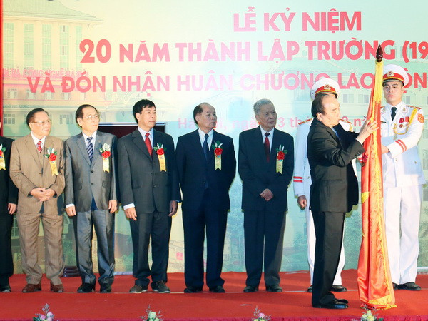Thủ tướng Nguyễn Xuân Phúc gắn Huân chương Lao động hạng Nhất lên Cờ truyền thống của Trường Đại học Kinh doanh và Công nghệ Hà Nội. (Ảnh: Thống Nhất/TTXVN) ĐH Kinh doanh Công nghệ phải là điển hình về đào tạo ngoài công lập ảnh 1