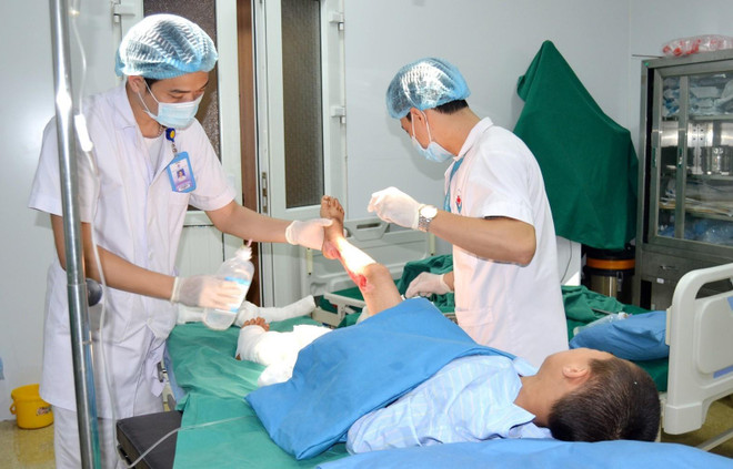 Các y bác sỹ Bệnh viện Đa khoa Hùng Vương điều trị vết thương cho bệnh nhi bị bỏng. (Ảnh: Trung Kiên/TTXVN) Bệnh nhi 9 tuổi bị nhiễm trùng nặng do điều trị bỏng bằng thuốc nam ảnh 1