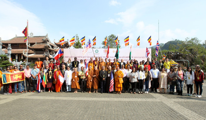 Đoàn đại biểu tham dự đại lễ Vesak chụp ảnh lưu niệm trên đỉnh Fansipan. (Ảnh: Quốc Khánh/TTXVN) Đoàn đại biểu quốc tế dự Đại lễ cầu quốc thái dân an ở đỉnh Fansipan ảnh 1