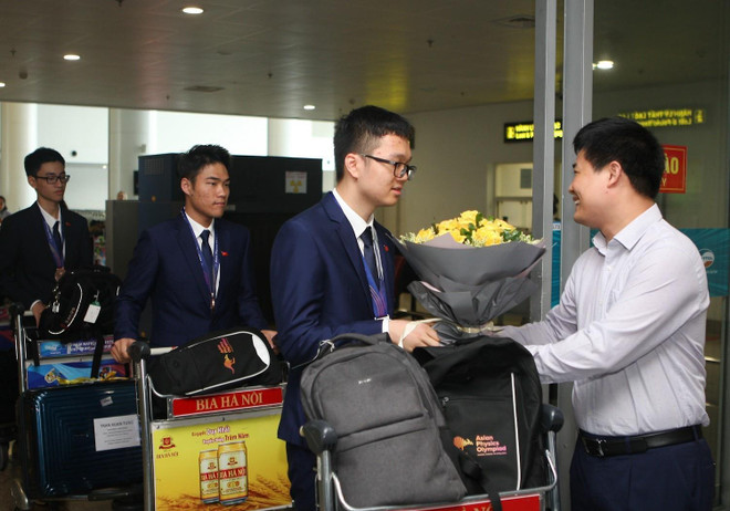Ông Sái Công Hồng - Phó Cục trưởng Cục Quản lý chất lượng Bộ Giáo dục và Đào tạo đón, tặng hoa chúc mừng các thí sinh đội tuyển Việt Nam tham gia Olympic Vật lý châu Á lần thứ 20 năm 2019. (Ảnh: Thanh Tùng/TTXVN) Olympic Vật lý châu Á 2019: Mang vinh quang trở về cho đất nước ảnh 1