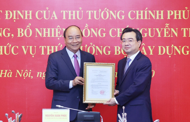 Thủ tướng Nguyễn Xuân Phúc trao Quyết định của Thủ tướng Chính phủ về việc điều động, bổ nhiệm ông Nguyễn Thanh Nghị, Ủy viên Trung ương Đảng giữ chức Thứ trưởng Bộ Xây dựng. (Ảnh: Thống Nhất/TTXVN) Thủ tướng trao quyết định bổ nhiệm Thứ trưởng Bộ Xây dựng ảnh 1