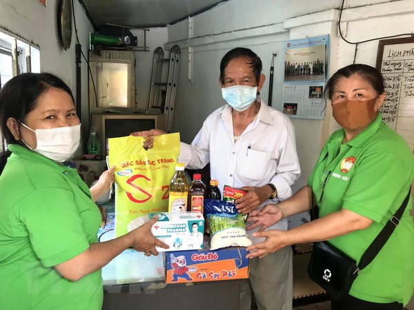 Bên cạnh việc chi hỗ trợ theo chính sách, người dân còn được nhận nhiều phần quà thiết yếu. (Ảnh: Thanh Vũ/TTXVN) TP.HCM thông qua gói hỗ trợ hơn 7.300 tỷ đồng cho 5 nhóm đối tượng ảnh 1