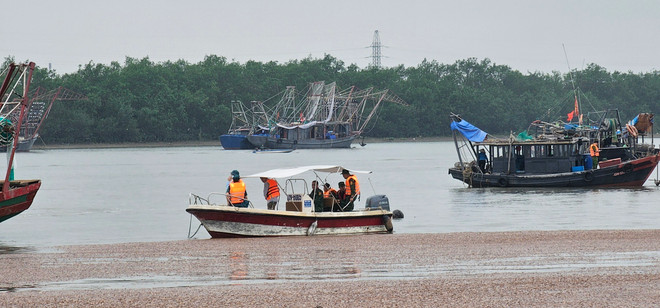 Lãnh đạo Thị xã Quảng Yên phối hợp với các lực lượng nỗ lực tìm kiếm cứu nạn 4 nạn nhân mất tích trên sông Chanh. (Ảnh: TTXVN phát) TTXVN_2504latthuyen2.jpg