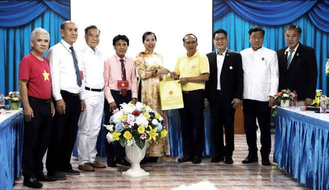 Thứ trưởng Ngoại giao Lê Thị Thu Hằng tặng quà cho kiều bào tại Thái Lan. (Ảnh: Đỗ Sinh/TTXVN) ttxvn_190_nam_thanh_lap_ngoi_chua_viet_co_tai_thai_lan_15-3.jpg