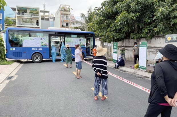Người dân Thành phố Hồ Chí Minh xếp hàng mua sắm tại xe buýt bán hàng bình ổn. (Ảnh: TTXVN phát) Dịch COVID-19: Đảm bảo lưu thông hàng hóa đi đôi với an toàn ảnh 1