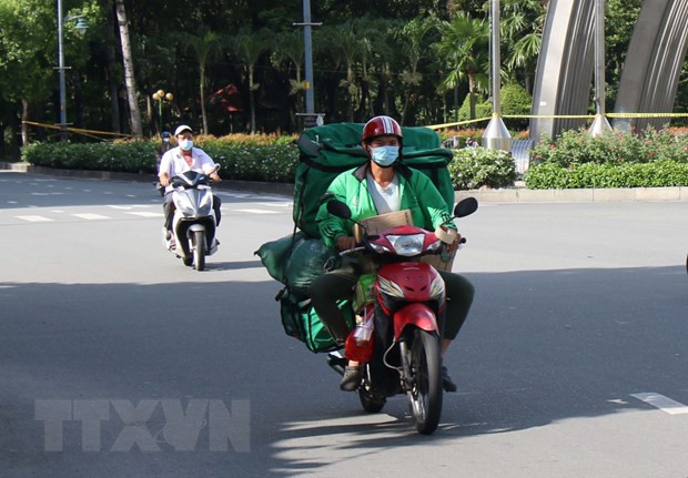 Giao hàng bằng xe hai bánh là một trong các loại hình được hoạt động tại Thành phố Hồ Chí Minh. (Ảnh: Tiến Lực/TTXVN) Dịch COVID-19: Đảm bảo lưu thông hàng hóa đi đôi với an toàn ảnh 2
