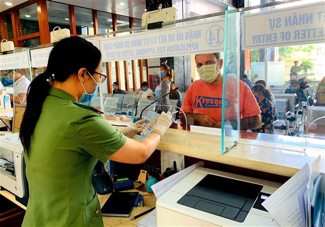 Cán bộ Công an cửa khẩu Tân Sơn Nhất chủ động trang bị đầy đủ khẩu trang, găng tay trong khi làm nhiệm vụ. (Ảnh: Thành Chung/TTXVN) Khai báo y tế đối với khách nhập cảnh đến từ hoặc đi qua Iran và Italy ảnh 1