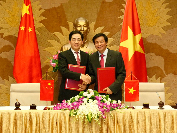 Tổng thư ký Quốc hội, Chủ nhiệm Văn phòng Quốc hội Nguyễn Hạnh Phúc và Đại sứ Hồng Tiểu Dũng trao Giấy chứng nhận bàn giao Dự án trao tặng Vật tư cho Quốc hội Việt Nam. (Ảnh: Văn Điệp/TTXVN) Quốc hội Việt Nam tiếp nhận quà tặng của Chính phủ Trung Quốc ảnh 1